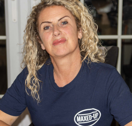 Woman wearing a blue maxeD-uP branded T-shirt indoors