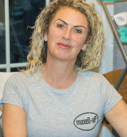 Woman wearing a grey maxeD-uP branded T-shirt indoors